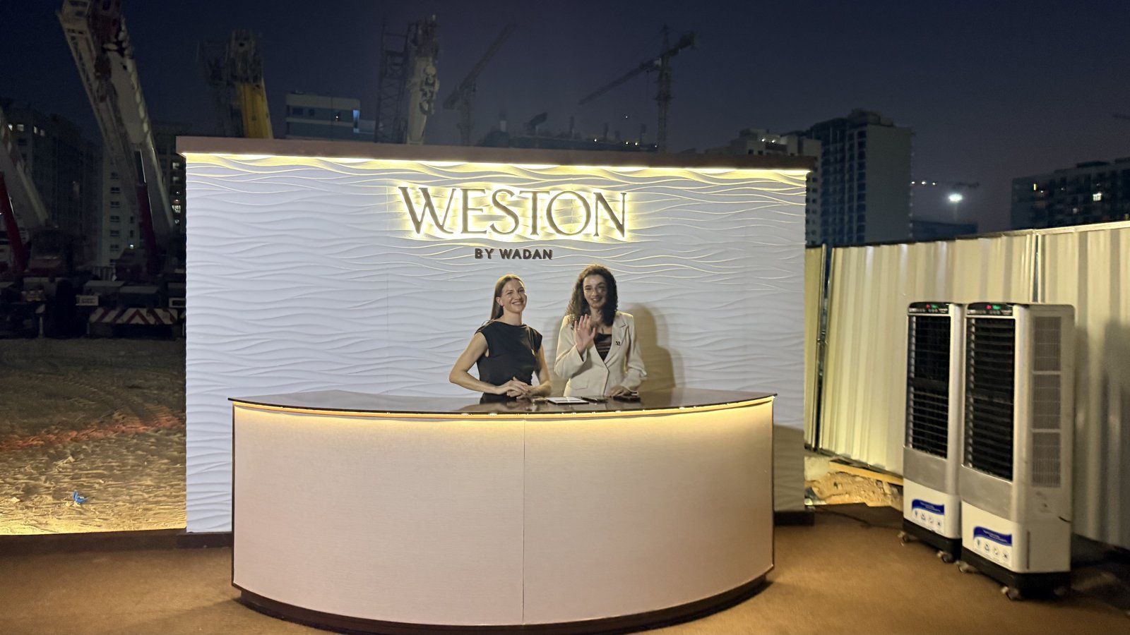 Illuminated Weston by Wadan registration desk with hostesses at the groundbreaking ceremony in Dubai